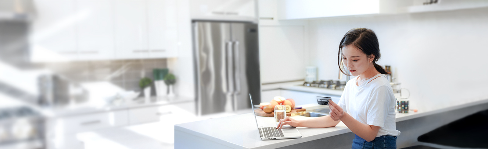 One lady standing in kitchen using her laptop