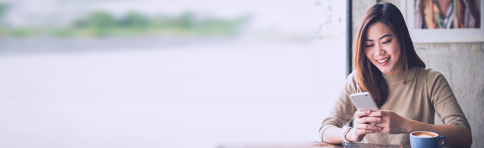 A woman looks at her phone in a café