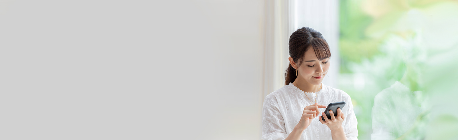 A lady in white shirt is using her mobile
