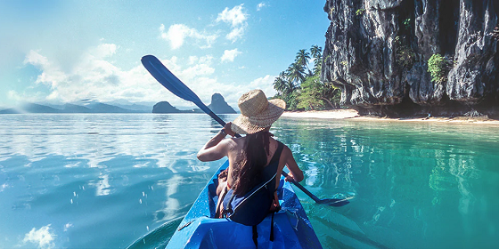 The lady paddling the kayak at sunny day