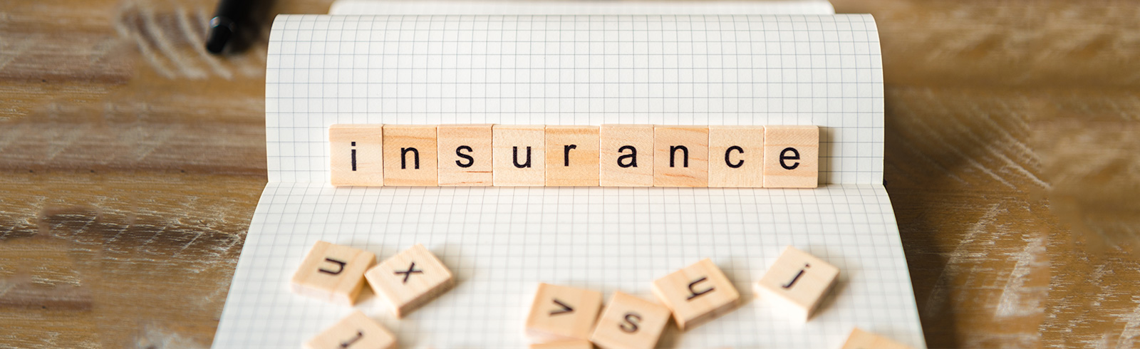 scrabble alphabets on grid paper spelling insurance, for SC insurance product