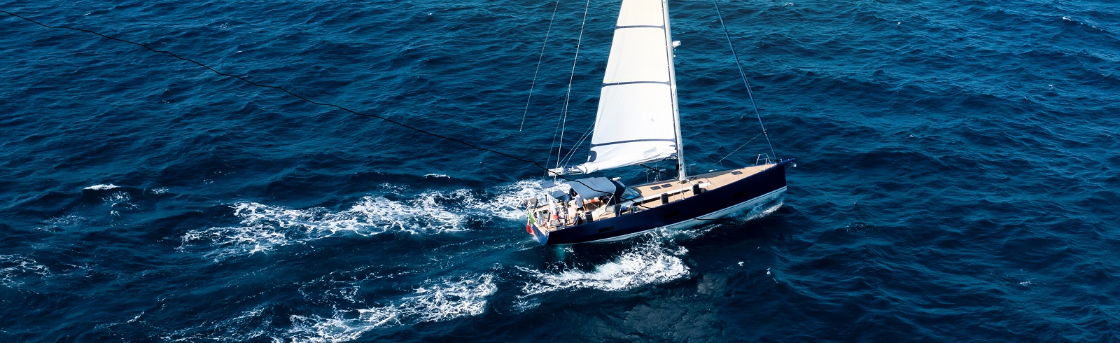View from above stunning aerial view of a sailboat sailing on a blue water during a sunny day costa smeralda sardinia italy