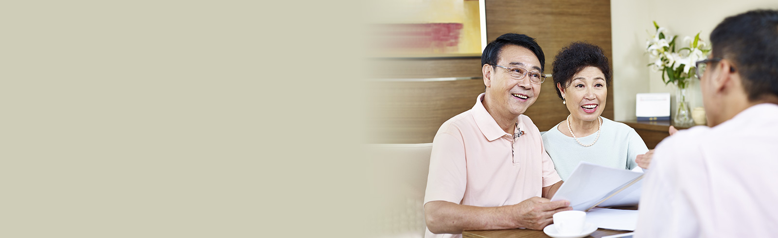 A senior couple holding documents and having discussion with another man