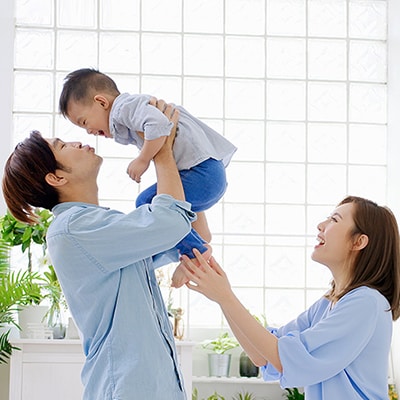 One man carrying the child and one lady is smiling