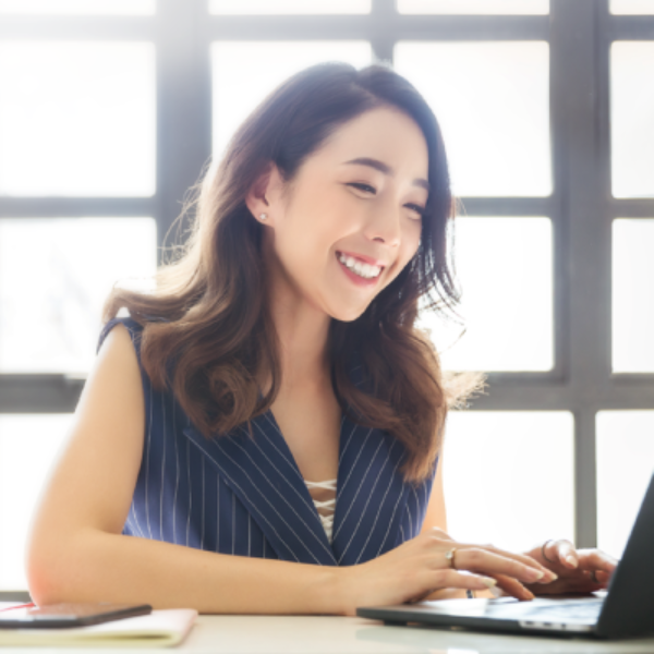 A lady using her laptop happily.