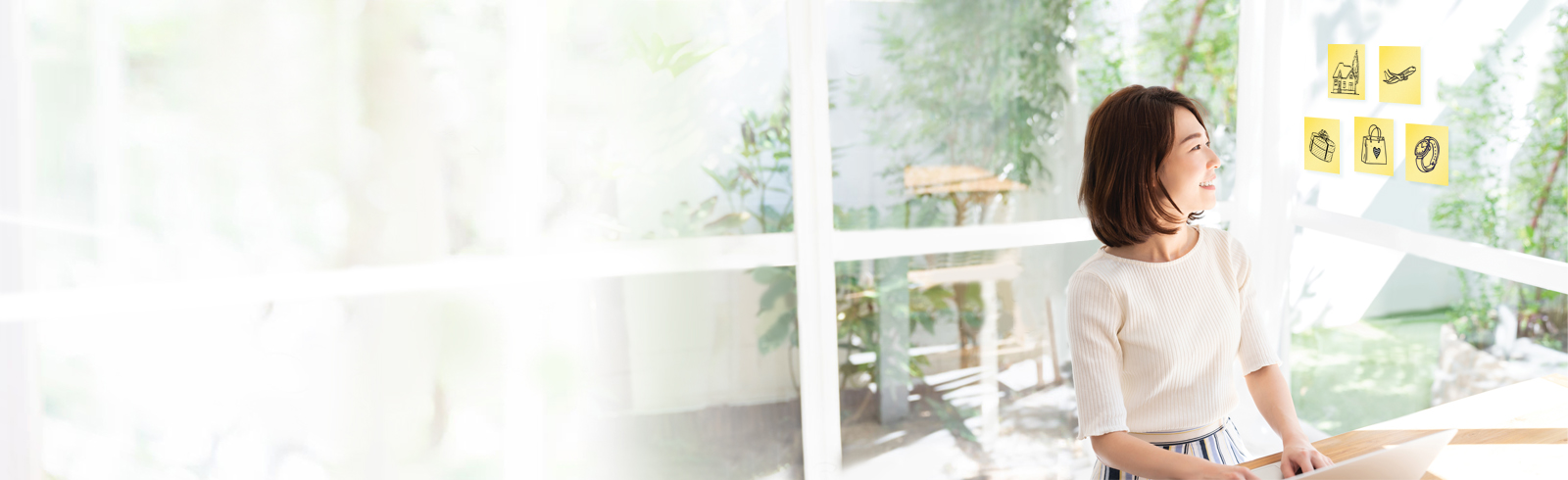 一名年輕女士正在觀看便利貼及使用她的桌上電腦